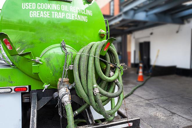 a technician pumping a grease trap in a commercial building in Depew